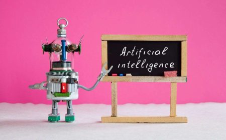 Artificial intelligence and machine learning cocnept. Funny robotic futuristic character, black chalkboard with handwritten text Artificial intelligence. Pink background.